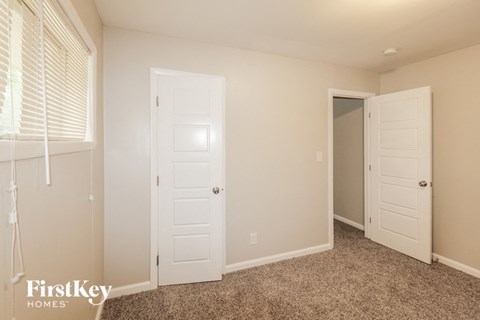 a bedroom with two white doors and a closet