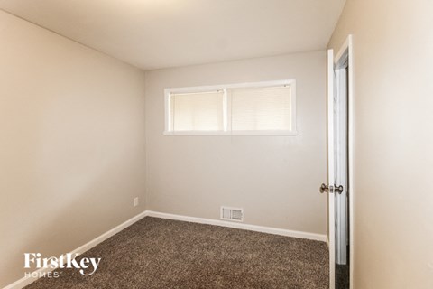 the living room of a home with carpet and a window
