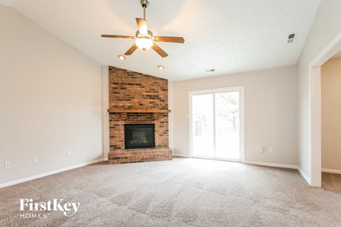the living room with fireplace and ceiling fan