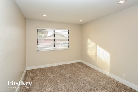 a spacious living room with carpet and a window