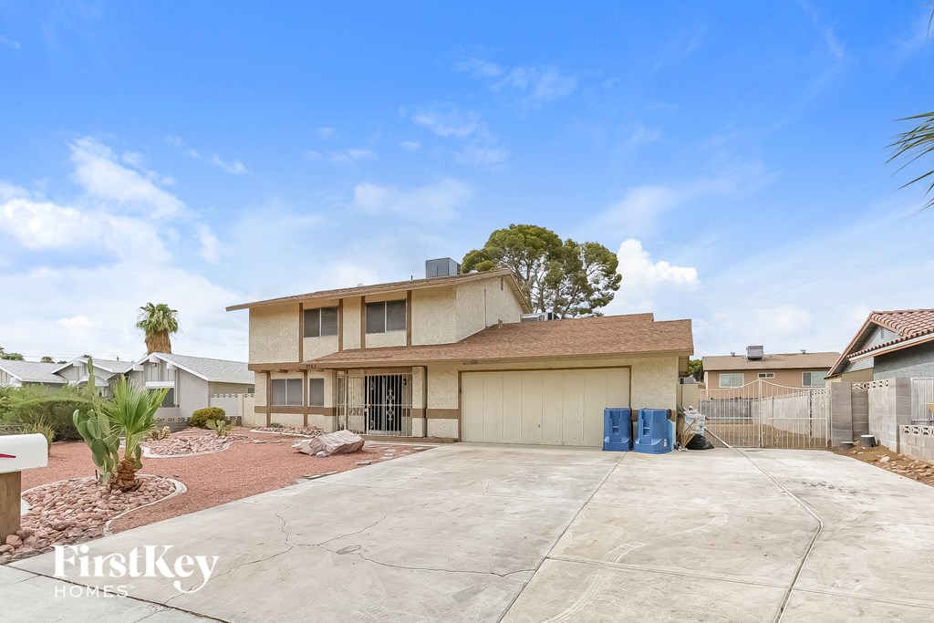 A house with a garage and a driveway in front of it.