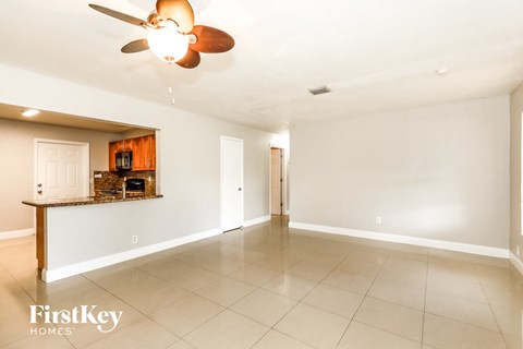A spacious room with a ceiling fan and tiled flooring.