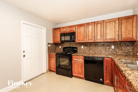 A kitchen with wooden cabinets and a black stove top oven.