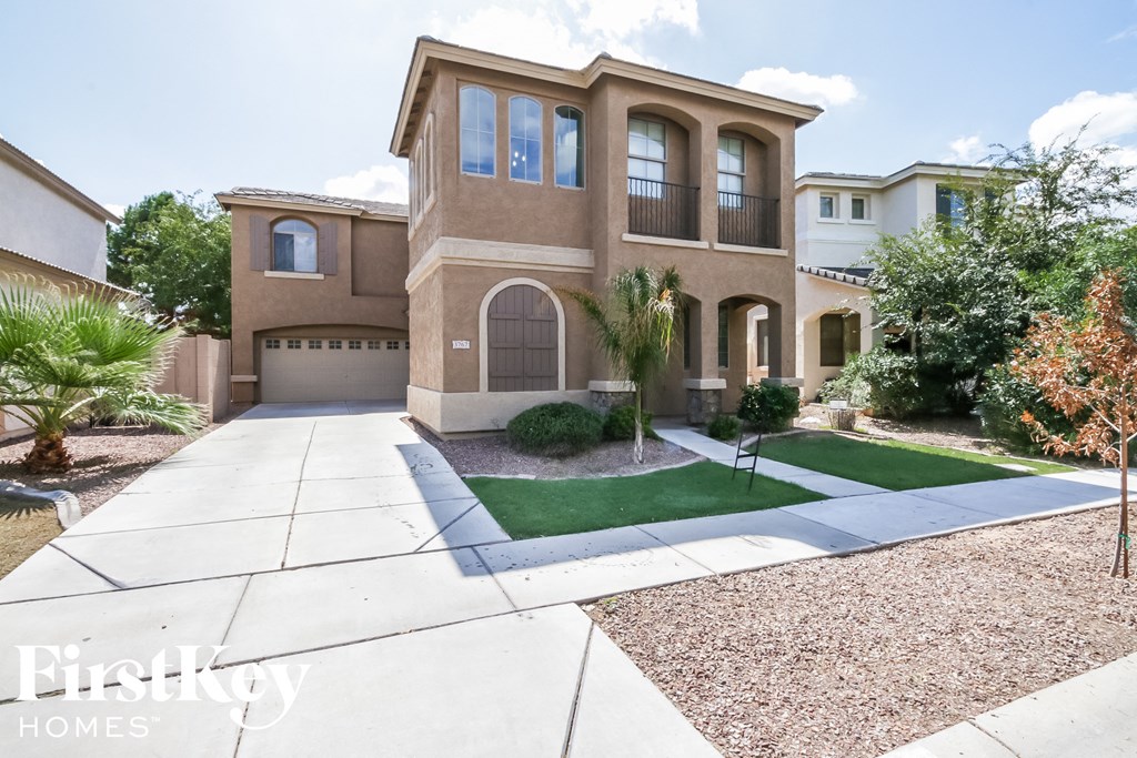 a house with a driveway and lawn in front of it