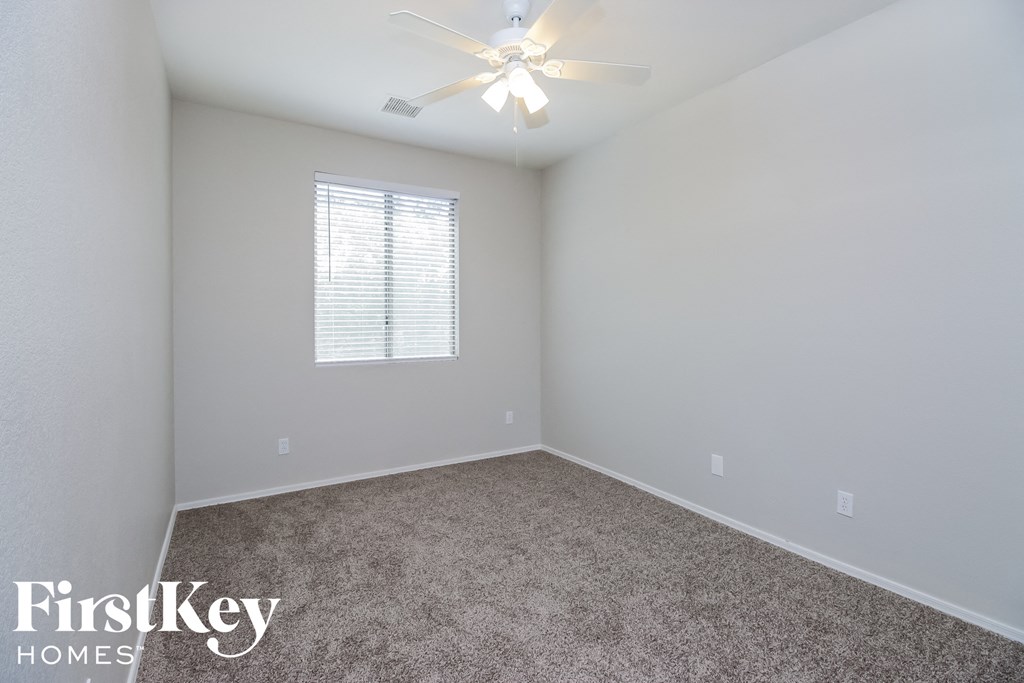 a bedroom with a carpeted floor and a ceiling fan