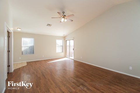 a living room with wood floors and a ceiling fan