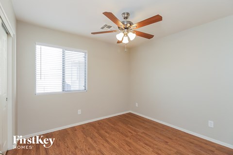 a bedroom with a ceiling fan and a window