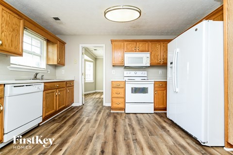 A kitchen with wooden cabinets and a white fridge.