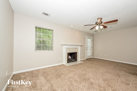 the living room has a fireplace and a ceiling fan
