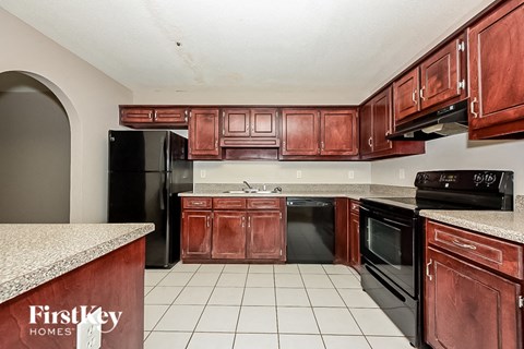 a kitchen with wooden cabinets and black appliances