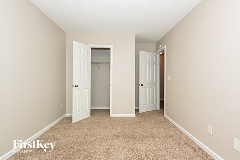 a bedroom with two closet doors and a carpeted floor