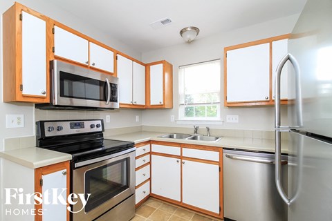 a kitchen with white cabinets and stainless steel appliances
