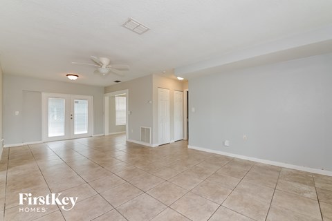 A spacious room with a fan and tiled flooring.