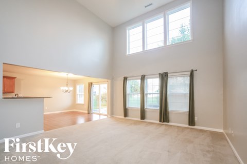 A spacious room with a large window and a sliding glass door.