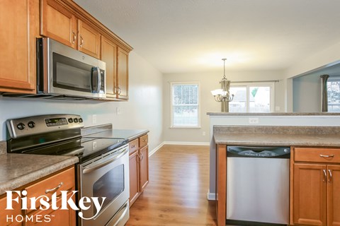 A kitchen with wooden cabinets and a stainless steel dishwasher.