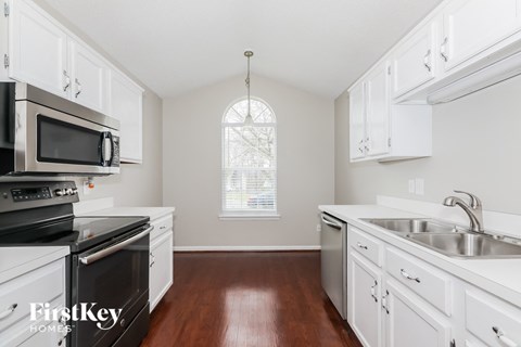 A kitchen with white cabinets and a stainless steel oven.