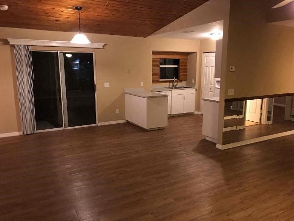 A kitchen area with a white cabinet and a window with blinds.