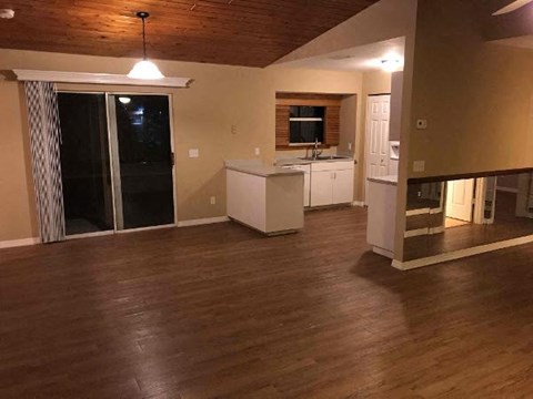 A kitchen area with a white cabinet and a window with blinds.