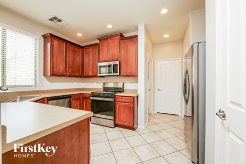 A kitchen with wooden cabinets and a refrigerator.