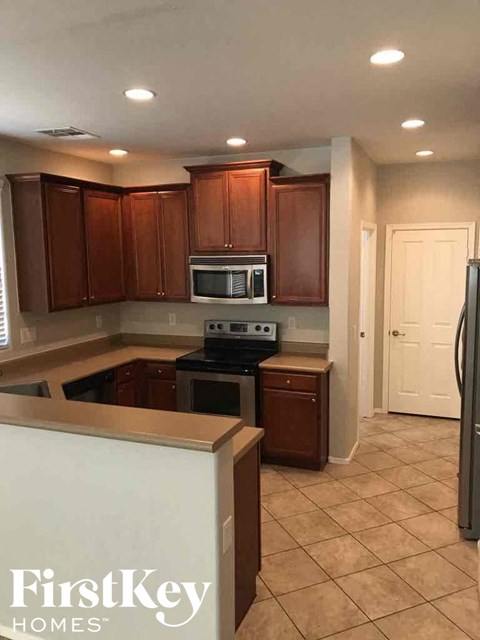 A kitchen with brown cabinets and a white refrigerator.