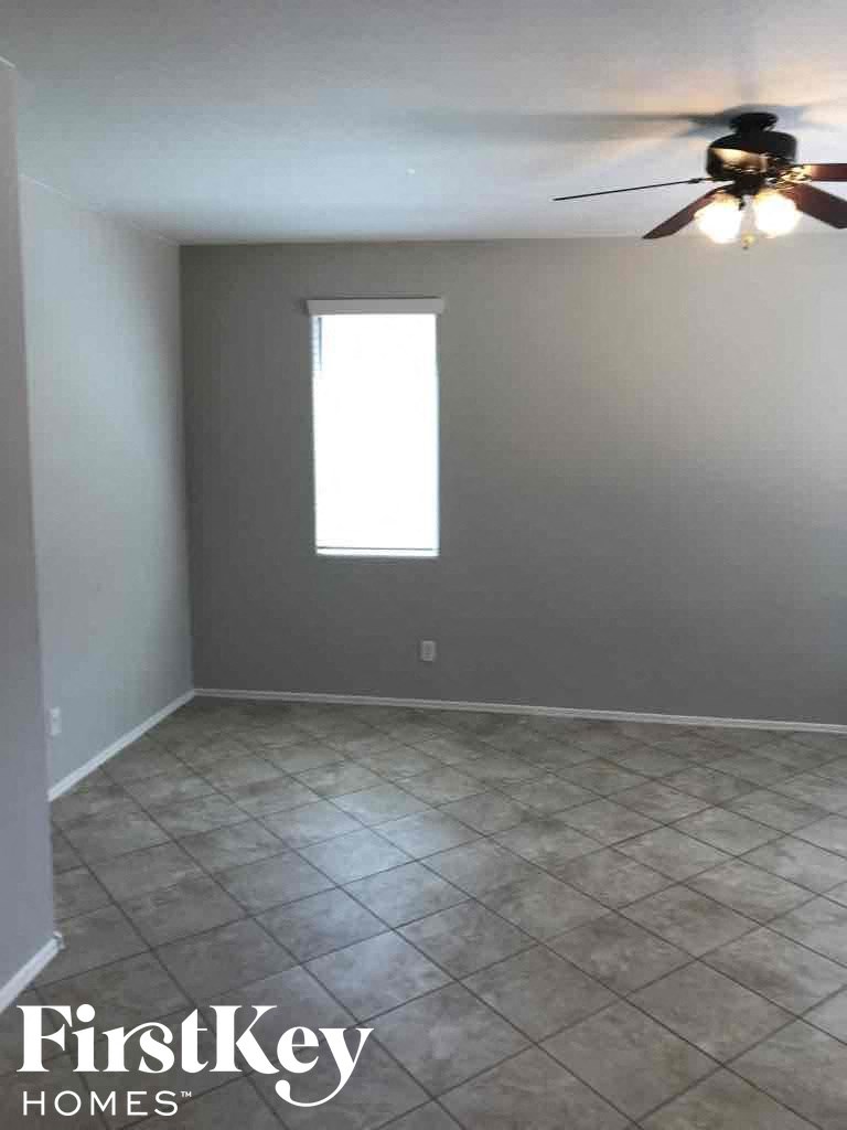 A room with a ceiling fan and a window.