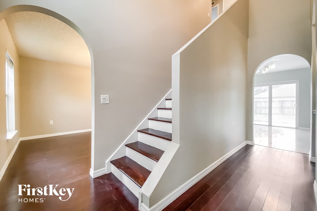 a staircase in a home with wood floors and white stairs