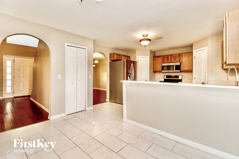 a kitchen with a white counter top and a door to a hallway