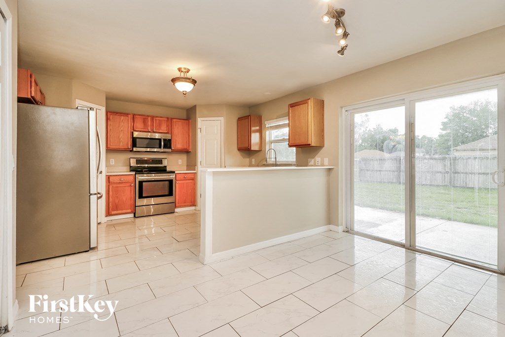the kitchen is open to the backyard and has stainless steel appliances