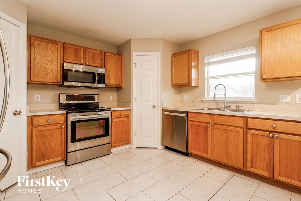 a kitchen with wooden cabinets and stainless steel appliances