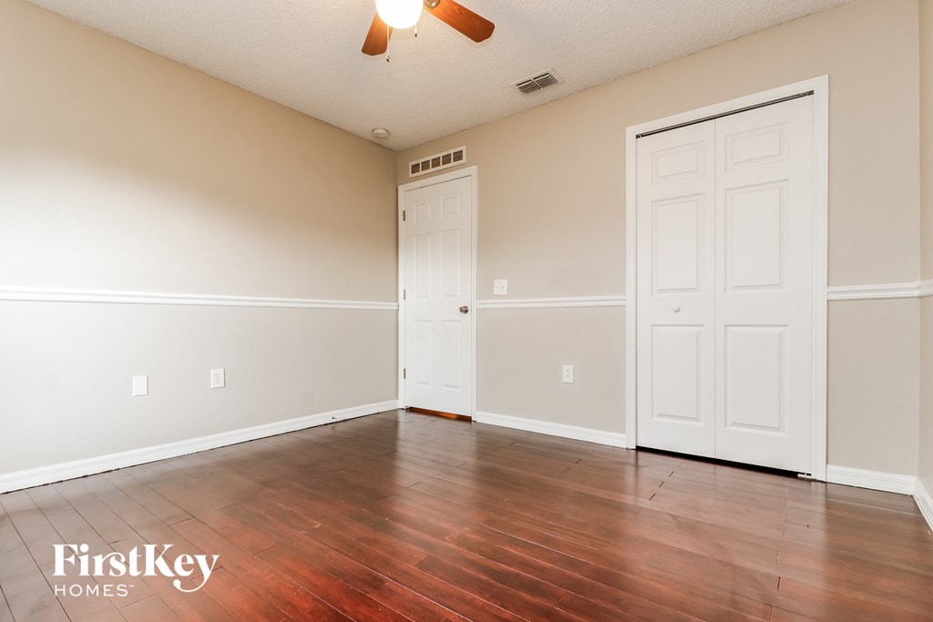 a empty living room with wood floors and white doors