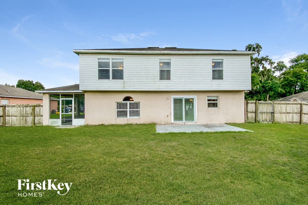 a white house with a yard and a white fence