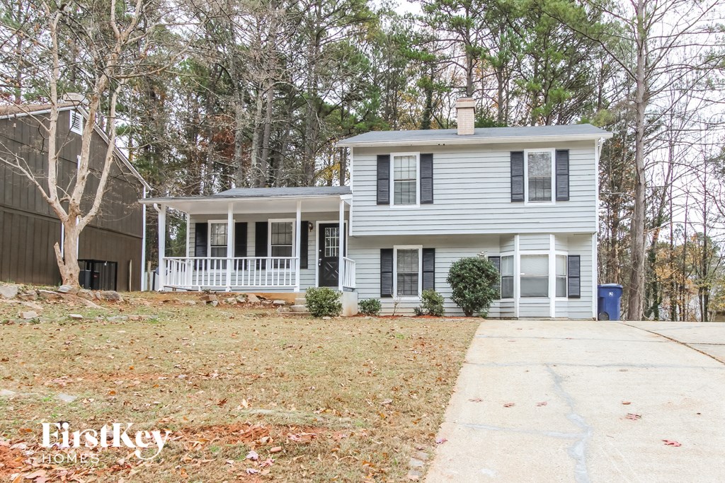 a white house with black shutters and a driveway