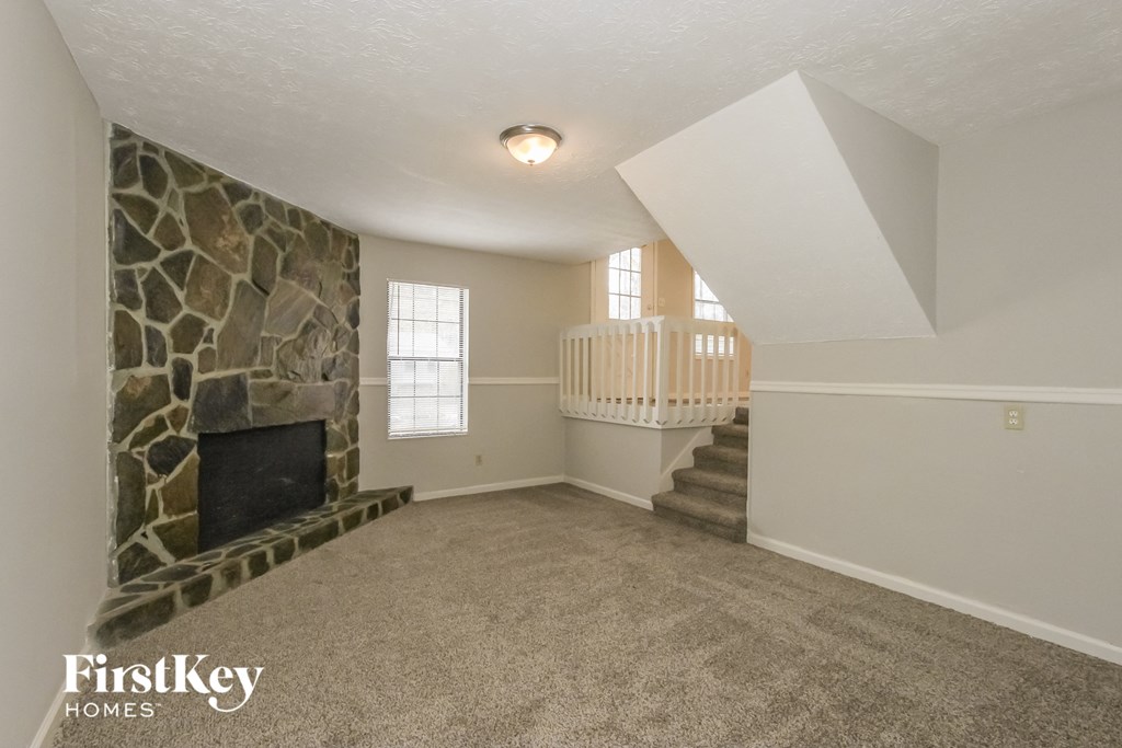 the living room of an empty house with a stone fireplace