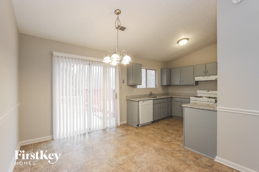 an empty kitchen with a sliding glass door to the living room