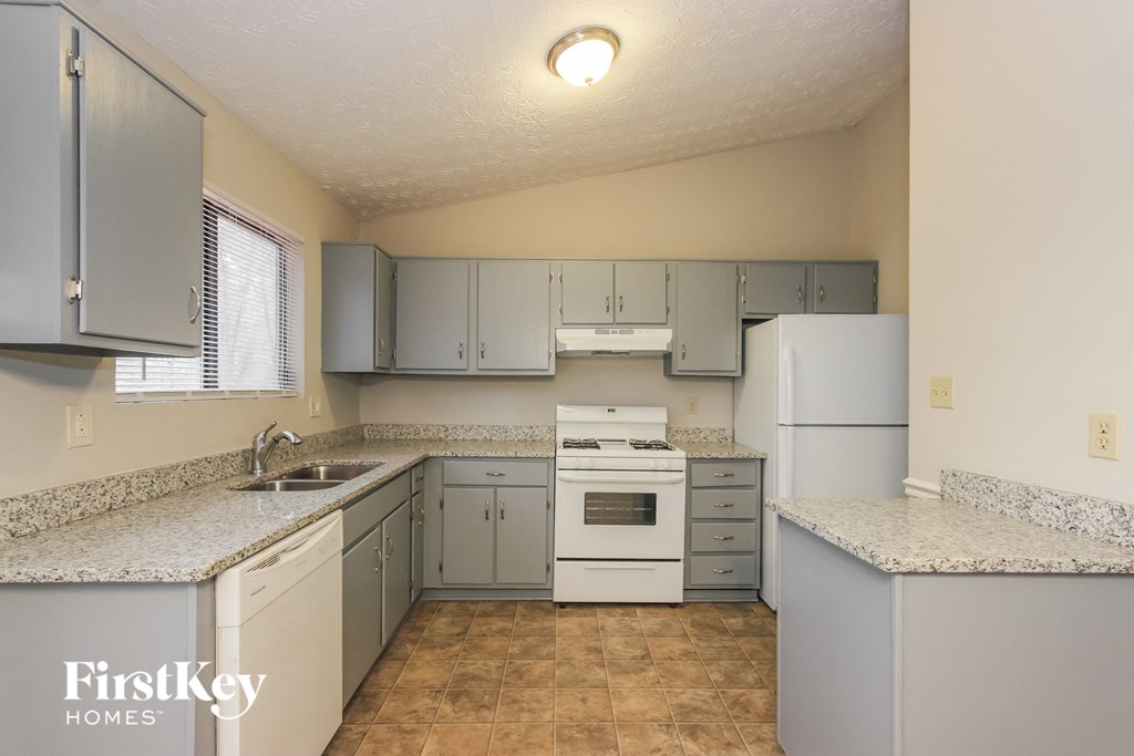 a kitchen with white appliances and granite counter tops