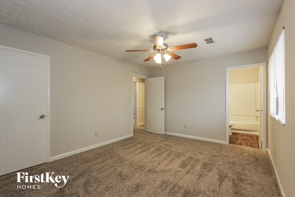 the living room of an empty house with a ceiling fan