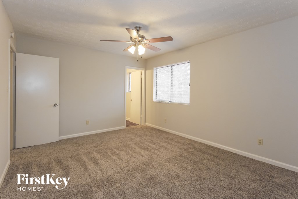 the living room of an empty house with a ceiling fan