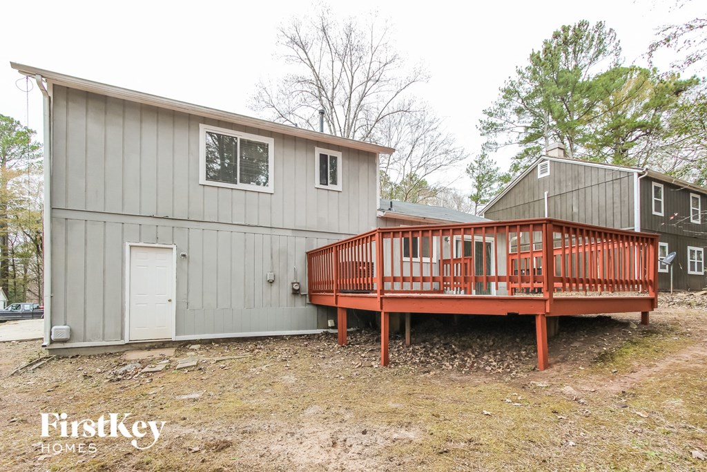 a large gray house with a red deck