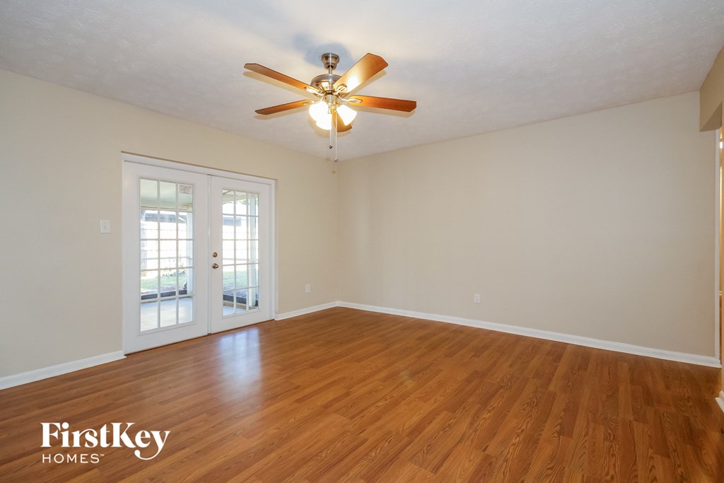the living room of an empty house with a ceiling fan