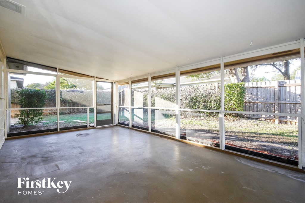 an empty living room with glass doors and a backyard