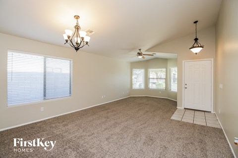 an empty dining room with a white door and ceiling fans