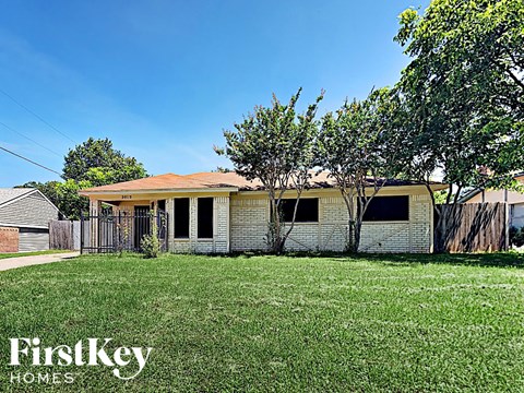 a small house with a yard and a fence