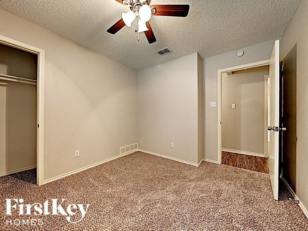 the bedroom of an empty house with a ceiling fan