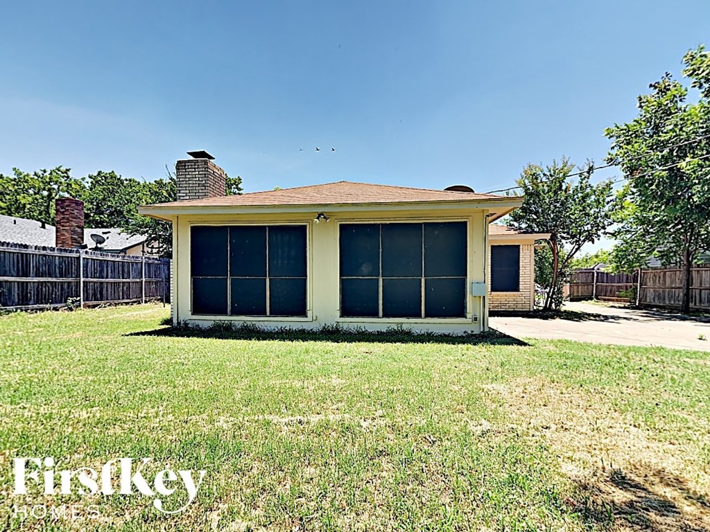 a small house with a yard and a fence