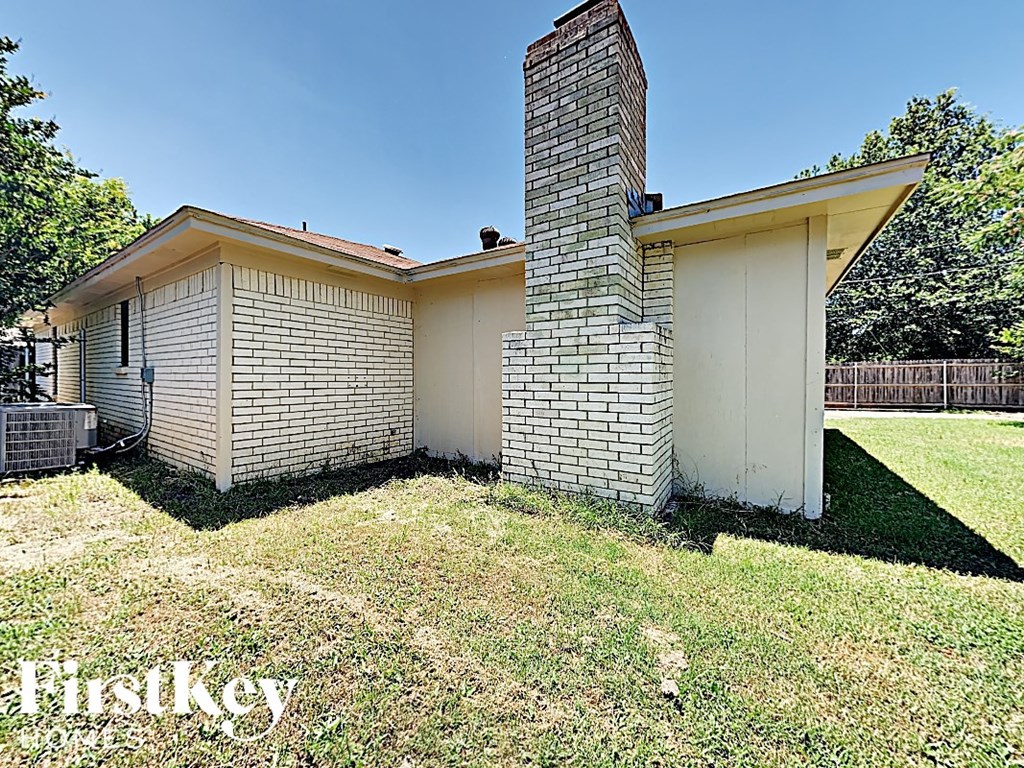 the backyard of a brick house with a brick chimney