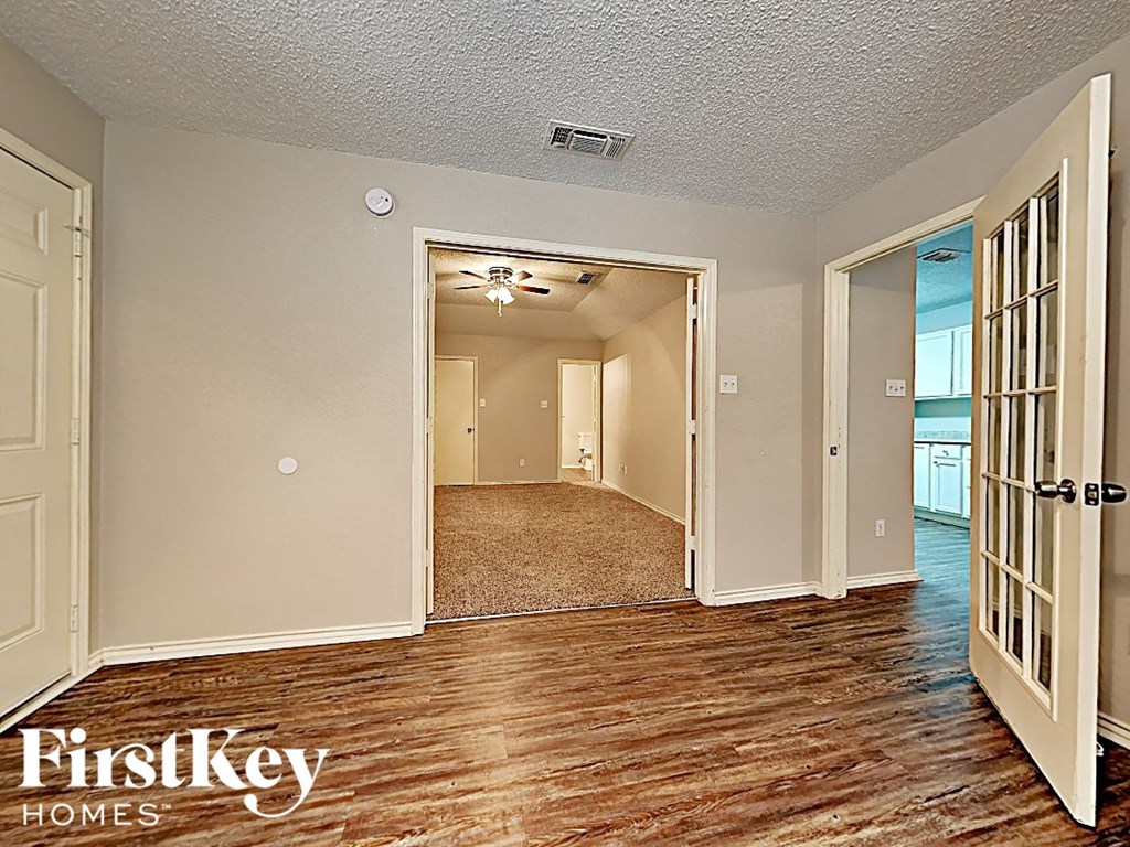 the living room and dining room of a house with wood flooring