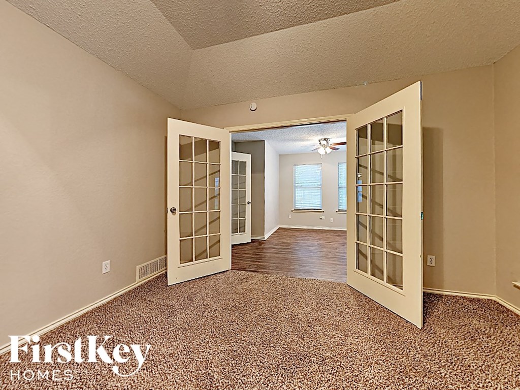 the living room and dining room of an empty house doors