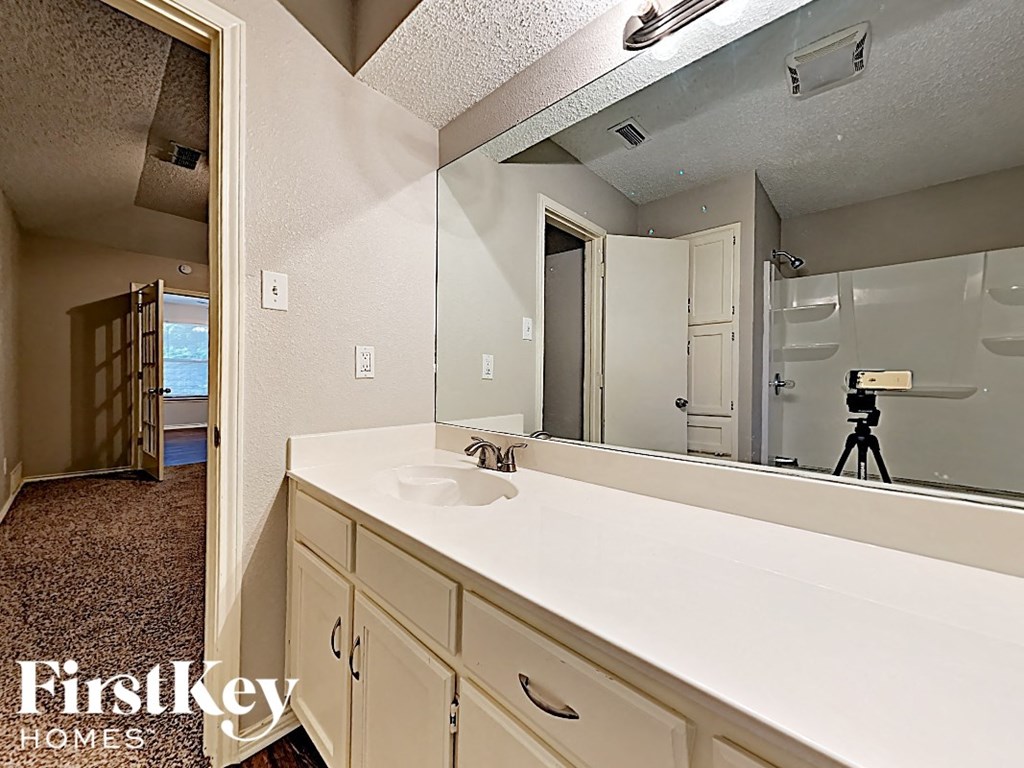 a bathroom with a large mirror and a white sink