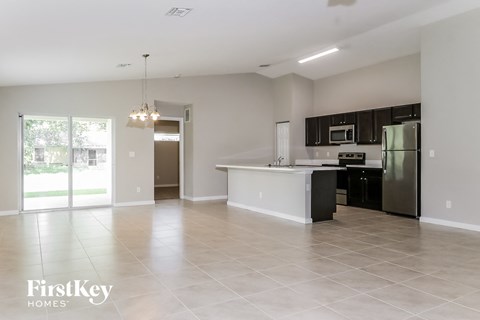 A spacious kitchen with a refrigerator, microwave, and oven.