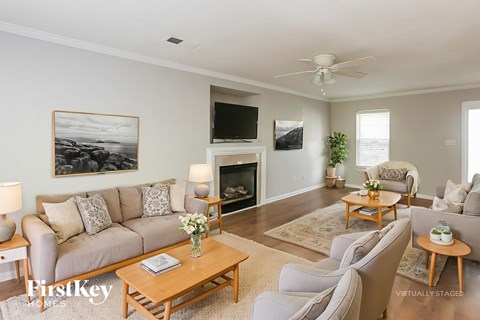 A living room with a grey couch, a wooden coffee table, and a painting on the wall.